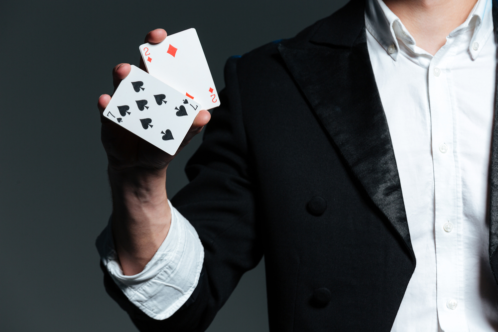 Magician holding playing cards